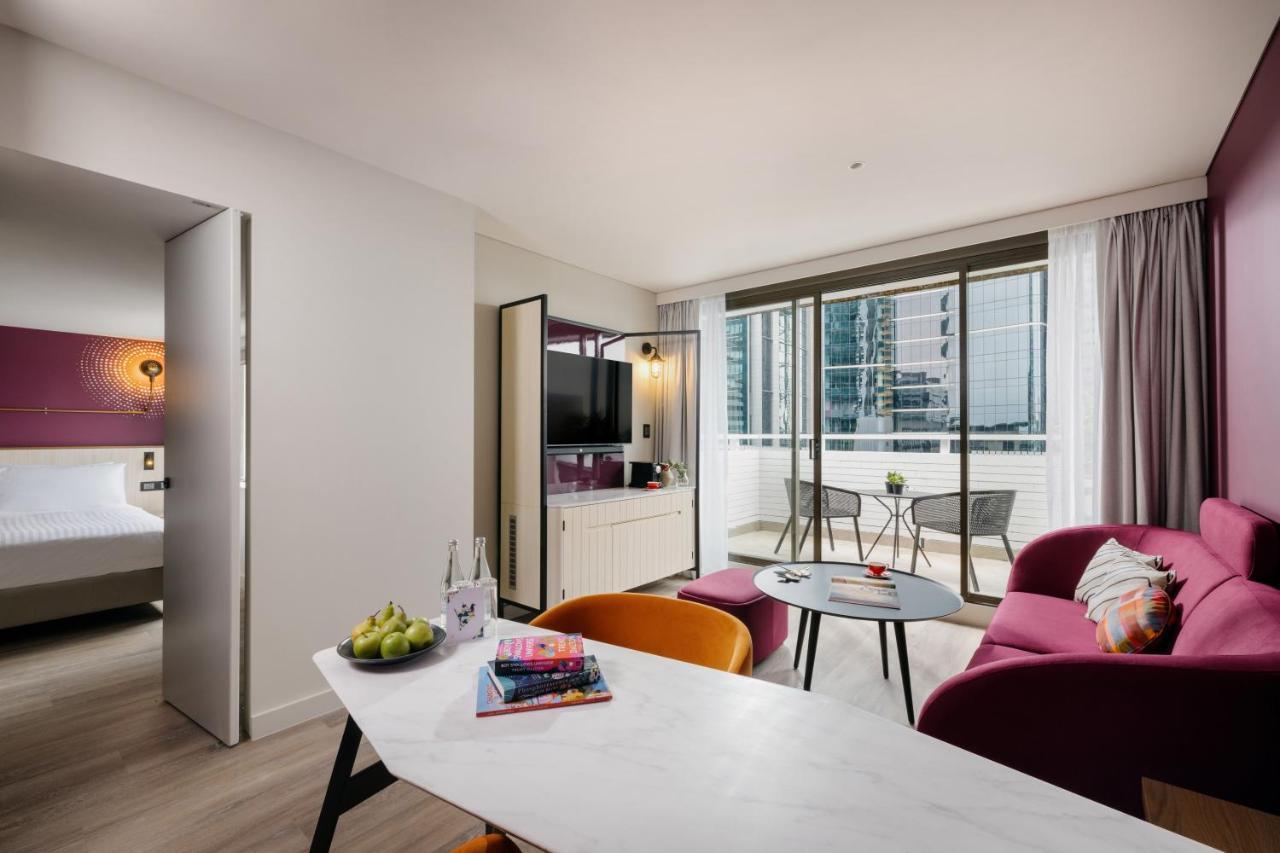 Suite mit 1 Schlafzimmer und einem Balkon mit Blick auf die Stadt.