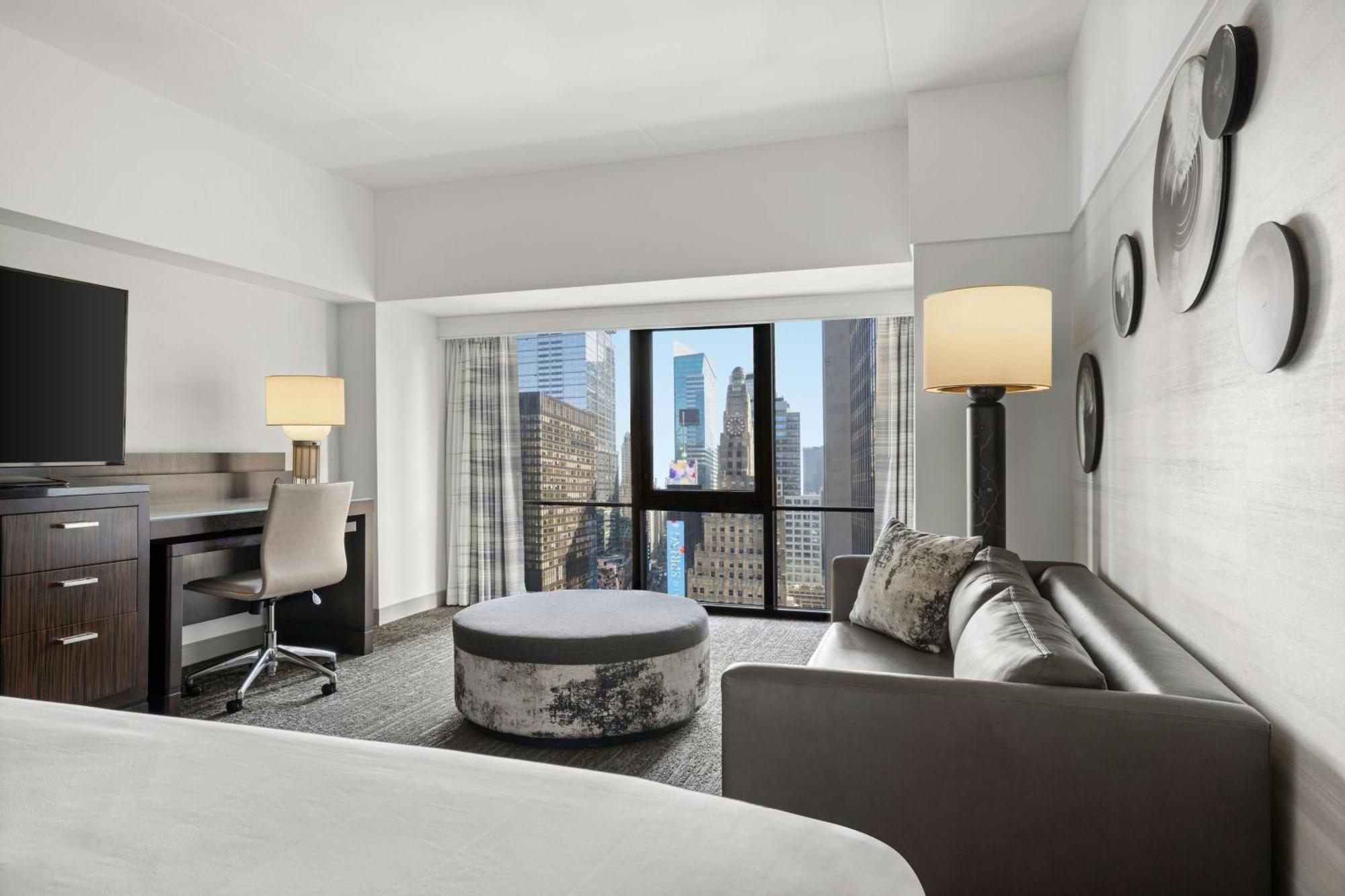 Zimmer mit Kingsize-Bett, Schlafsofa (auf Anfrage) und Blick auf den Times Square