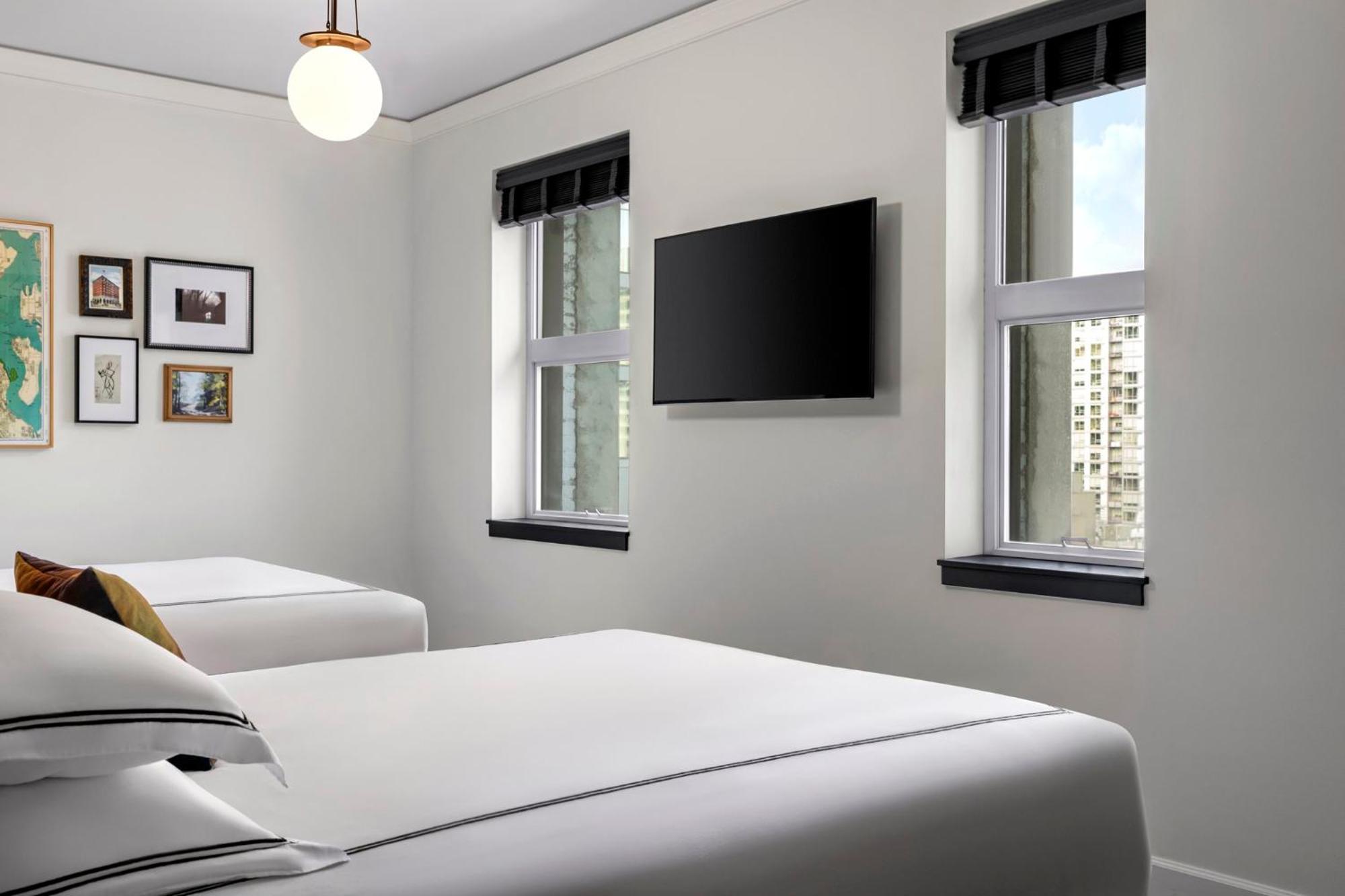 Kamer met 2 Queensize Bedden en Bad Geschikt voor Gasten met een Lichamelijke Beperking