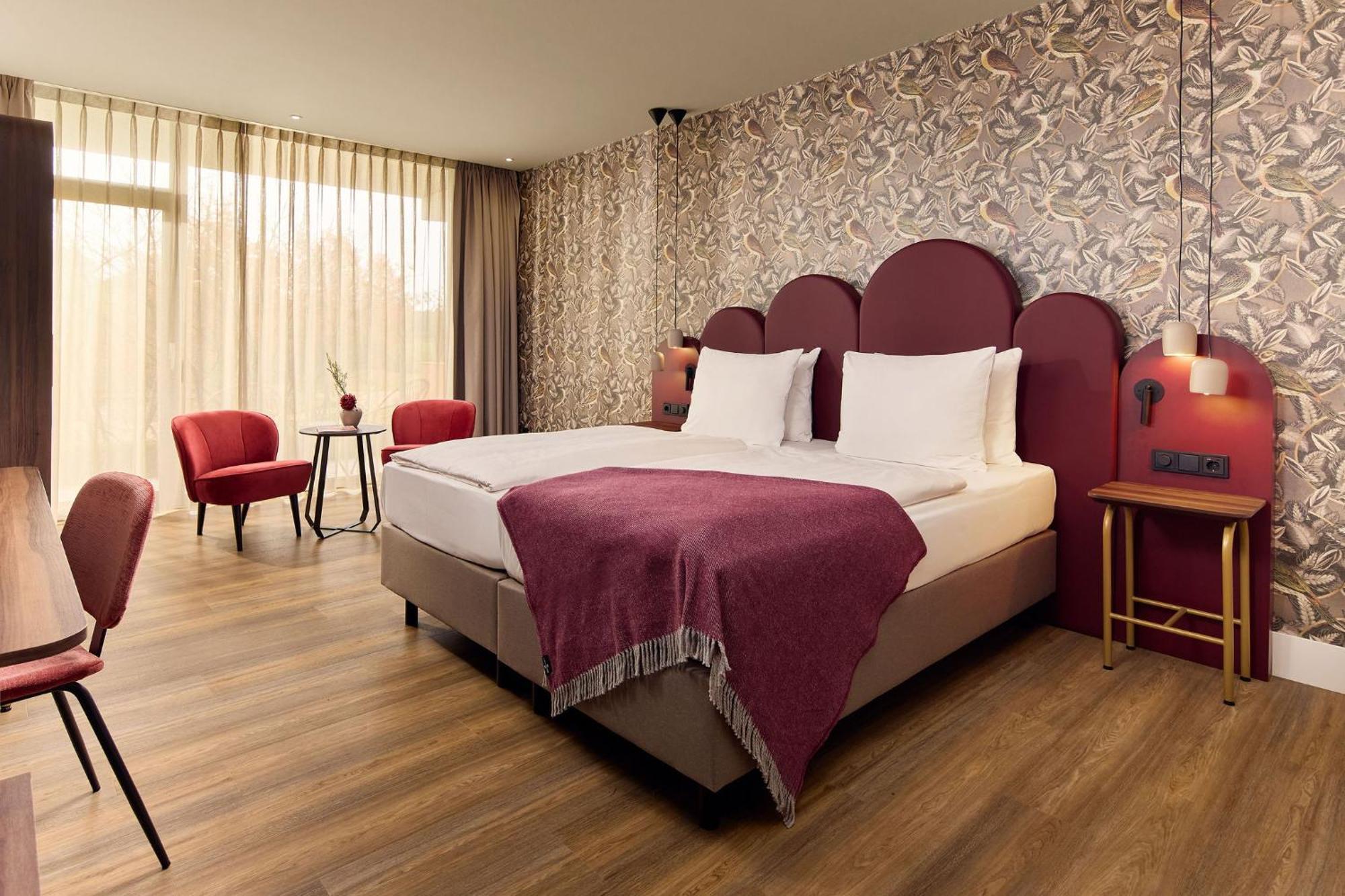 Zimmer mit Kingsize-Bett und Gartenblick.