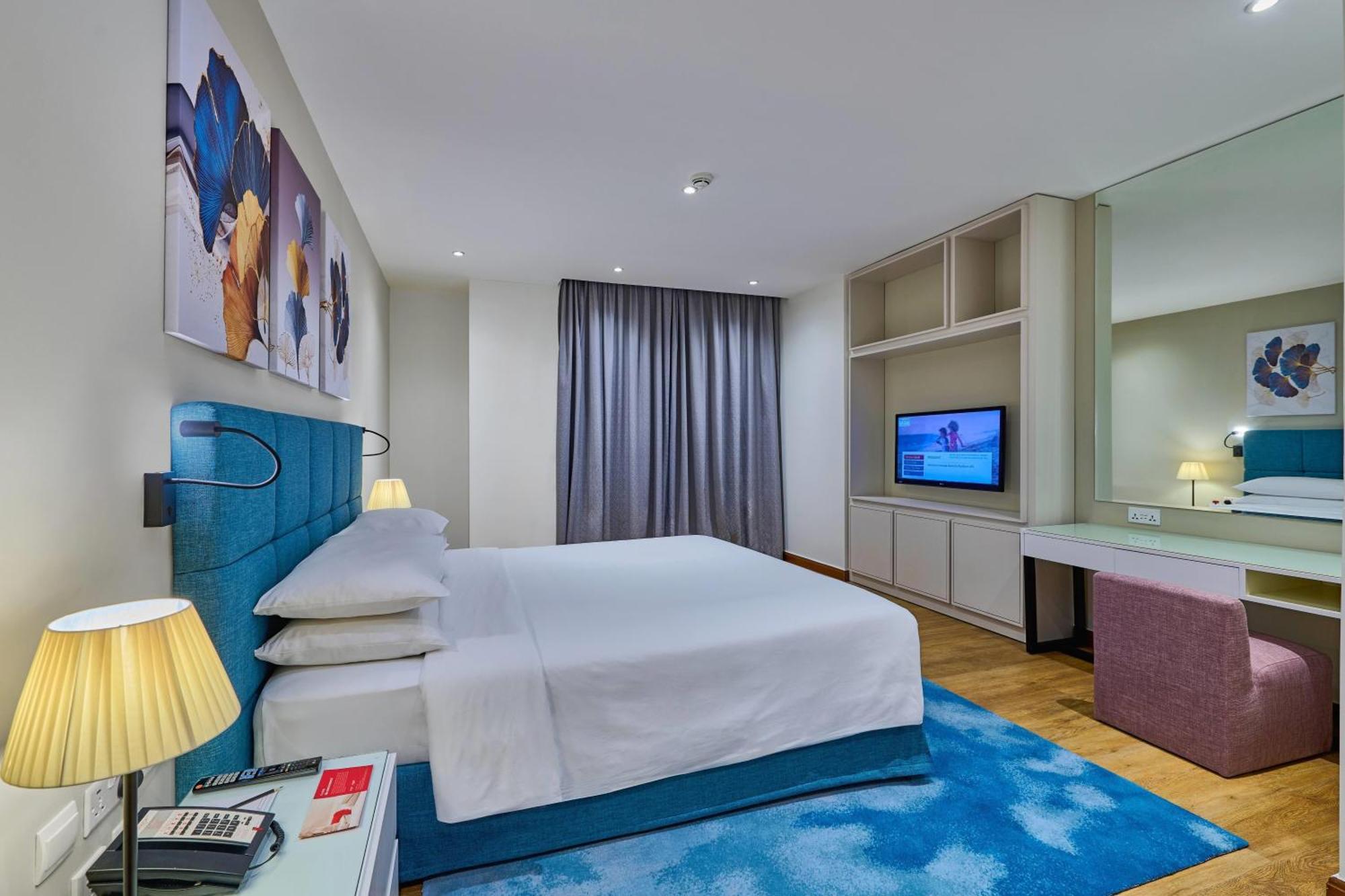 Suite de 1 dormitorio con cama extragrande, balcón y vistas parciales al mar